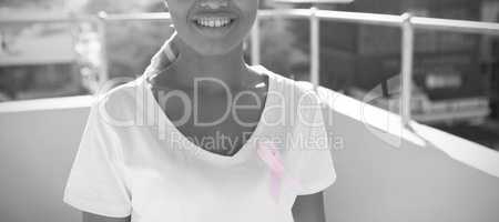 Smiling woman in the city with breast cancer awareness