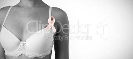 Mid section of woman in white bra with pink ribbon