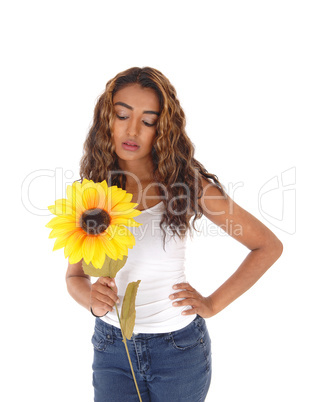 Beautiful teenager girl standing and looking at her sunflower