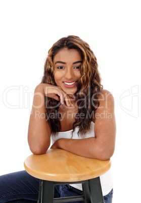 Beautiful happy young woman sitting behind a chair