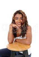 Beautiful happy young woman sitting behind a chair