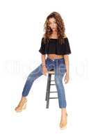 Serious looking young woman sitting on bar chair