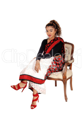 Smiling beautiful East Indian woman sitting in armchair