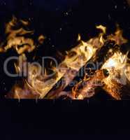 burning wooden logs in the fire at night