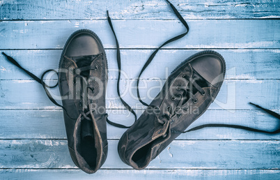 pair of black textile sneakers with loosened laces