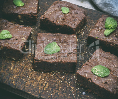 baked square pieces of brownie pie on a wooden board