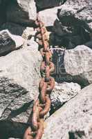 old rusty chain lies in the middle of the stones