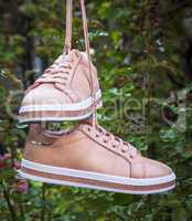 pair of female leather pink shoes hanging on a string
