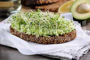 Sandwich with avocado and alfalfa sprouts