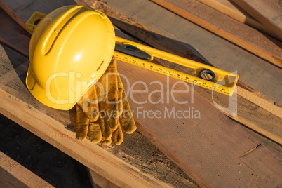 Abstract of Constrcution Hard Hat, Gloves and Level Resting on W