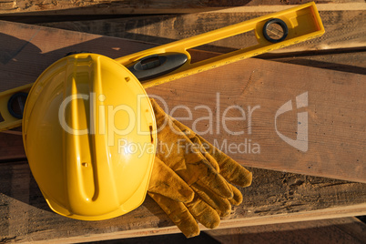 Abstract of Constrcution Hard Hat, Gloves and Level Resting on W