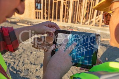 Male and Female Construction Workers Reviewing Building on Compu