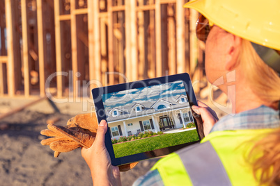 Female Construction Worker Reviewing House Photo on Computer Pad