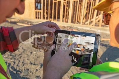 Male and Female Construction Workers Reviewing Kitchen on Comput