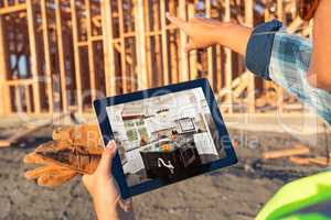 Female Construction Worker Reviewing Kitchen on Computer Pad at