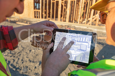 Male and Female Construction Workers Reviewing Kitchen Drawing o