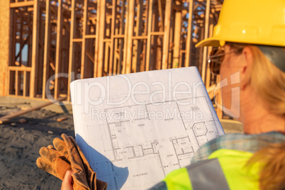 Female Construction Worker with House Plans at Construction Site
