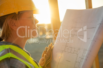 Female Construction Worker with House Plans at Construction Site