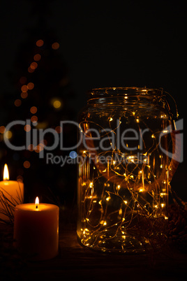 small electric garland in a glass jar with candles