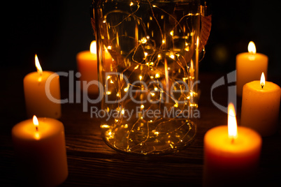 christmas candles with an electric garland in a jar