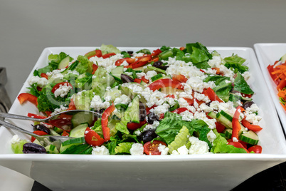 Greek salad including olives, feta cheese, lettuce, cucumbers, a