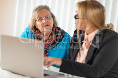 Woman Helping Senior Adult Lady on Laptop Computer