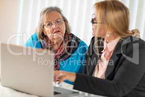 Woman Helping Senior Adult Lady on Laptop Computer