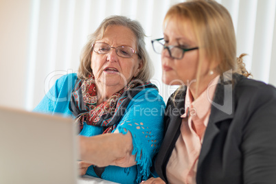 Woman Helping Senior Adult Lady on Laptop Computer