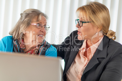 Woman Helping Senior Adult Lady on Laptop Computer