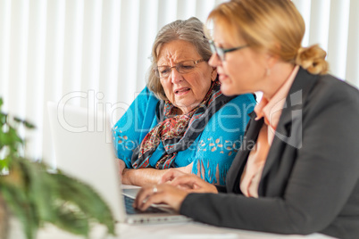 Woman Helping Senior Adult Lady on Laptop Computer