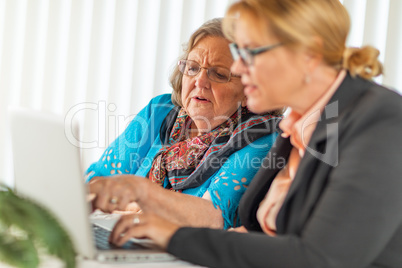 Woman Helping Senior Adult Lady on Laptop Computer