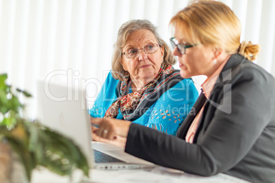 Woman Helping Senior Adult Lady on Laptop Computer