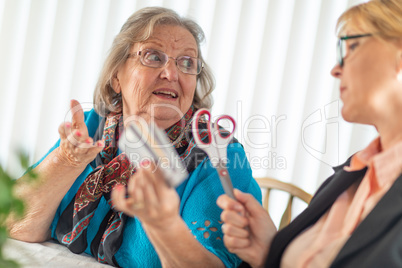 Financial Consultant Handing Scissors to Senior Lady Holding Cre