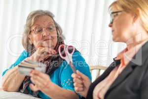 Financial Consultant Handing Scissors to Senior Lady Holding Cre