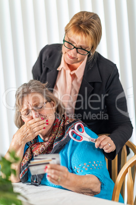 Financial Consultant Handing Scissors to Senior Lady Holding Cre