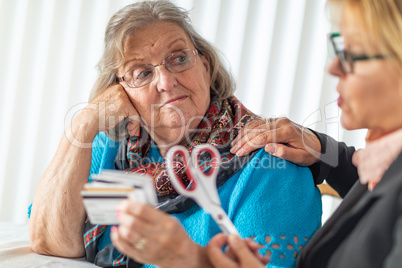 Financial Consultant Handing Scissors to Senior Lady Holding Credit Cards