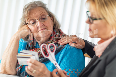 Financial Consultant Handing Scissors to Senior Lady Holding Credit Cards