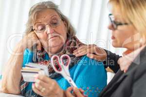 Financial Consultant Handing Scissors to Senior Lady Holding Credit Cards