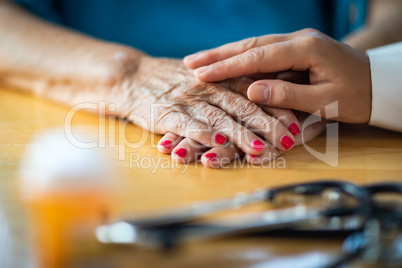 Younger Female Hands Touching Senior Adult Woman Hands Near Stet