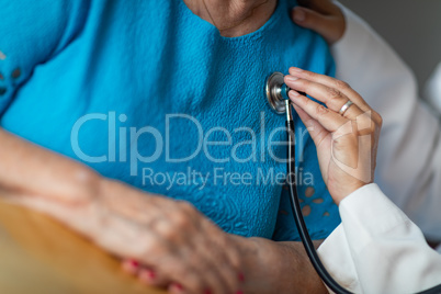 Female Doctor Checking The Heart With Stethoscope of Senior Adul