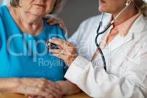 Female Doctor Checking The Heart With Stethoscope of Senior Woman