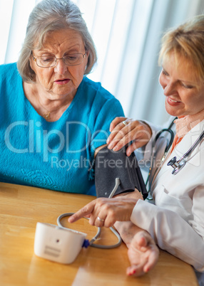 Senior Adult Woman Learning From Female Doctor to Use Blood Pressure Machine