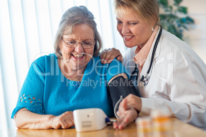 Senior Adult Woman Learning From Female Doctor to Use Blood Pressure Machine