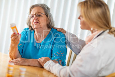 Female Doctor Talking with Senior Adult Woman About Medicine Pills