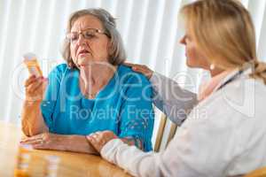 Female Doctor Talking with Senior Adult Woman About Medicine Pills