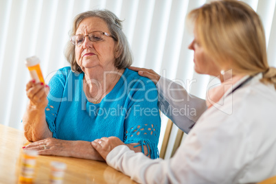 Female Doctor Talking with Senior Adult Woman About Medicine Pre