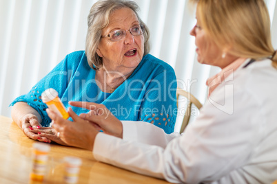 Female Doctor Talking with Senior Adult Woman About Medicine Pre