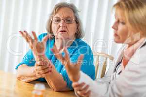 Female Doctor Talking with Senior Adult Woman About Hand Therapy