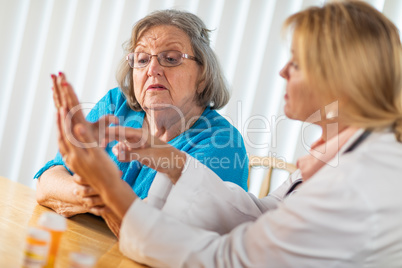 Female Doctor Talking with Senior Adult Woman About Hand Therapy