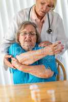 Female Doctor Helping Senior Adult Woman With Arm Exercises
